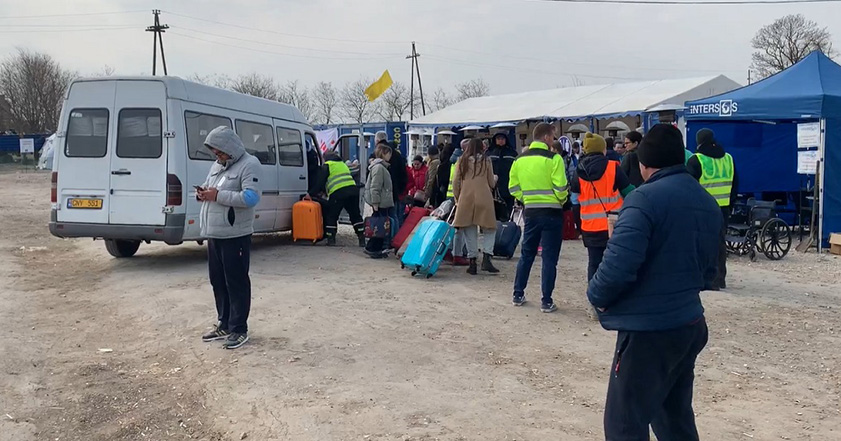 People getting off a van in Moldova with suitcases after fleeing Ukraine