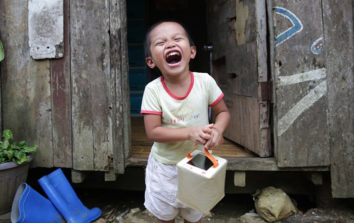 Little boy holding solar light in the Philippines