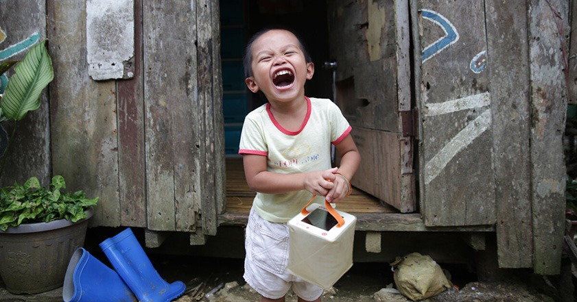Little boy holding solar light in the Philippines