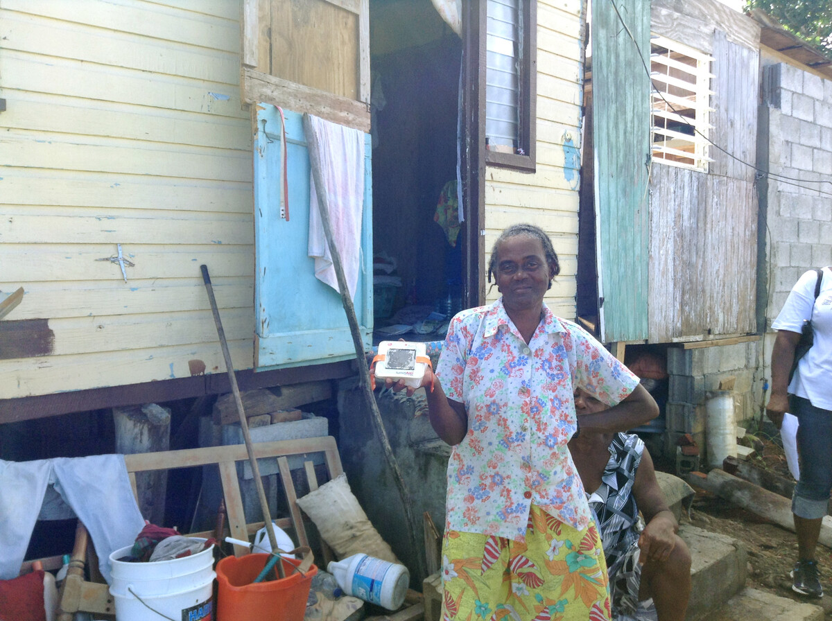 Woman standing in front of her home holding a solar light