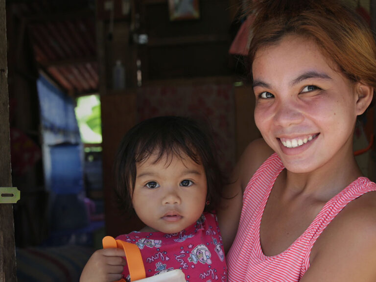 woman and daughter hold a solar light in the Philippines