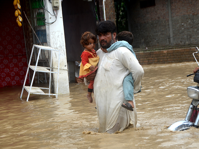 Man holding a child during flooding in Pakistan