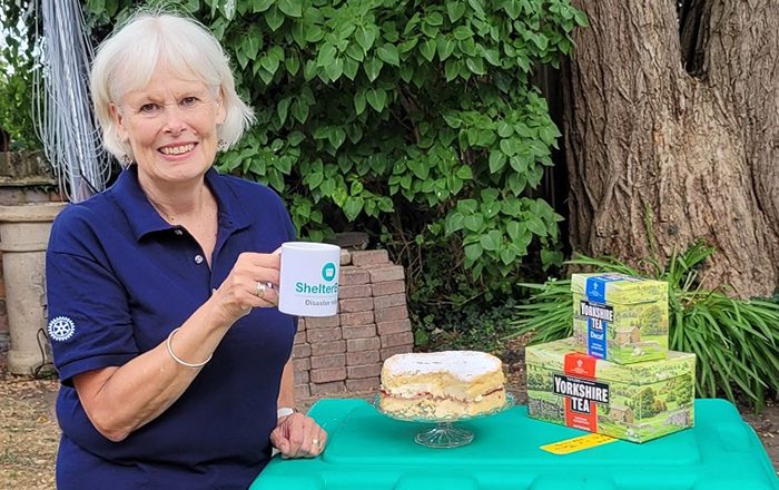 Woman with tea and cake on top of a green box