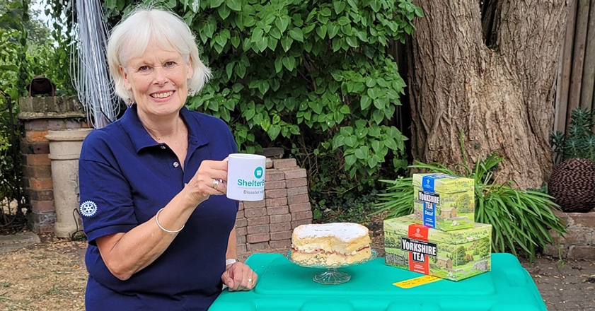 Woman with tea and cake on top of a green box