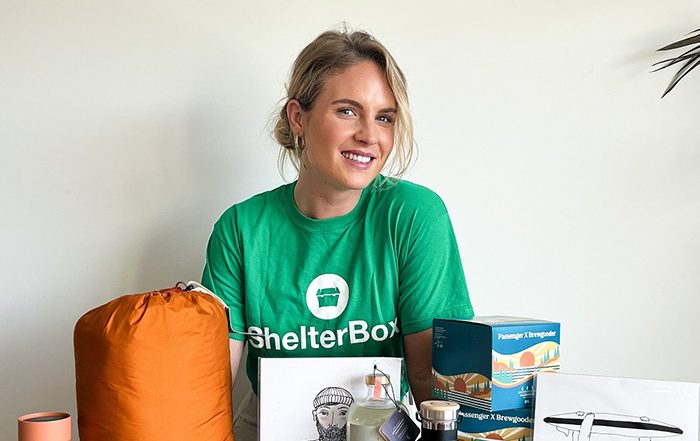 Women wearing ShelterBox t shirt next to table with items on it
