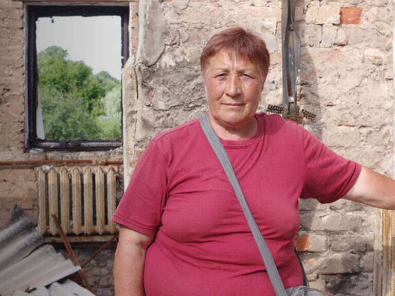 Woman standing in the middle of a destroyed home