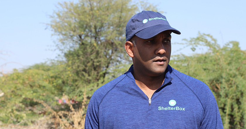 Man wearing blue top and cap