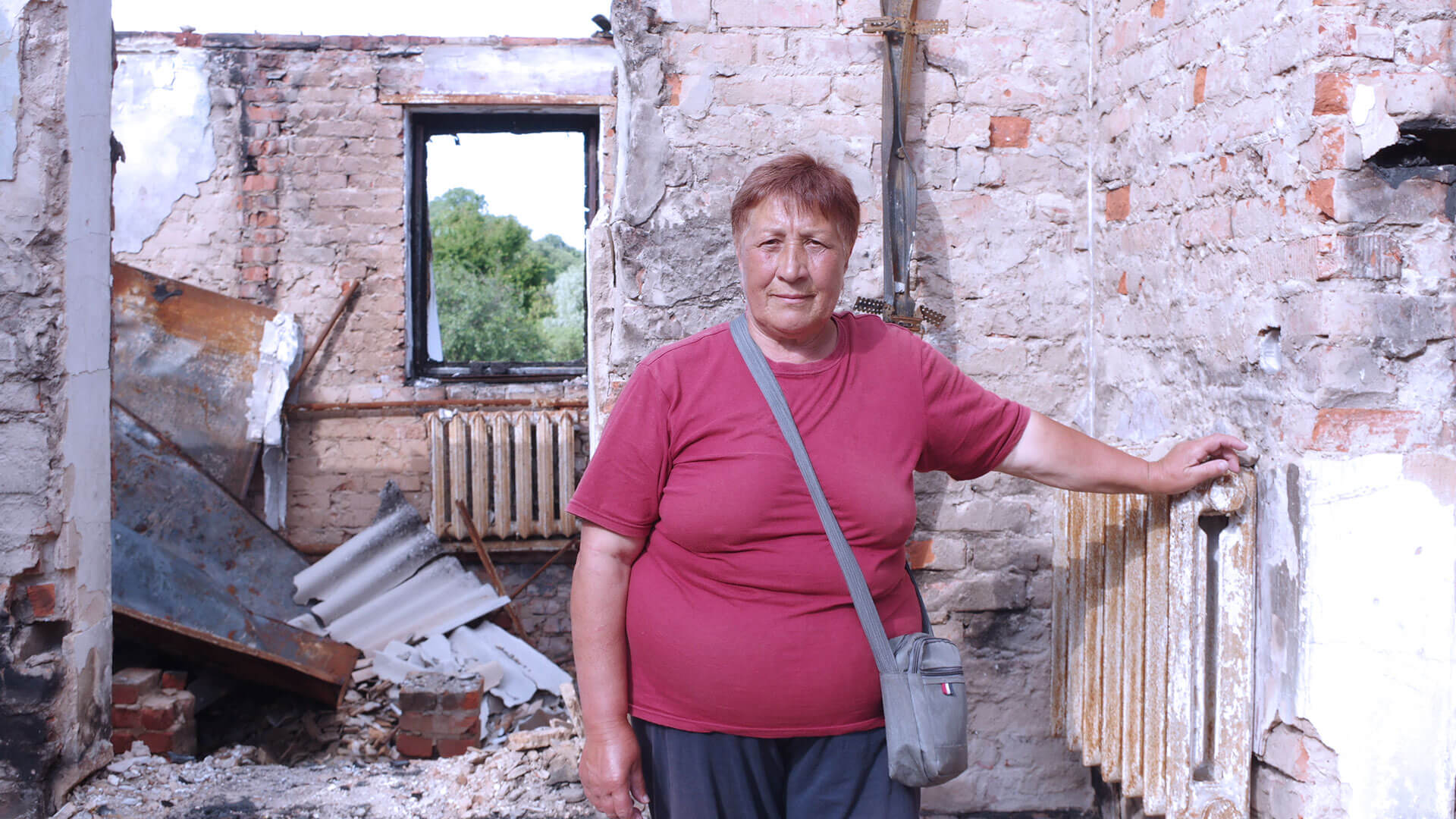 Woman stands in her destroyed home in Ukraine
