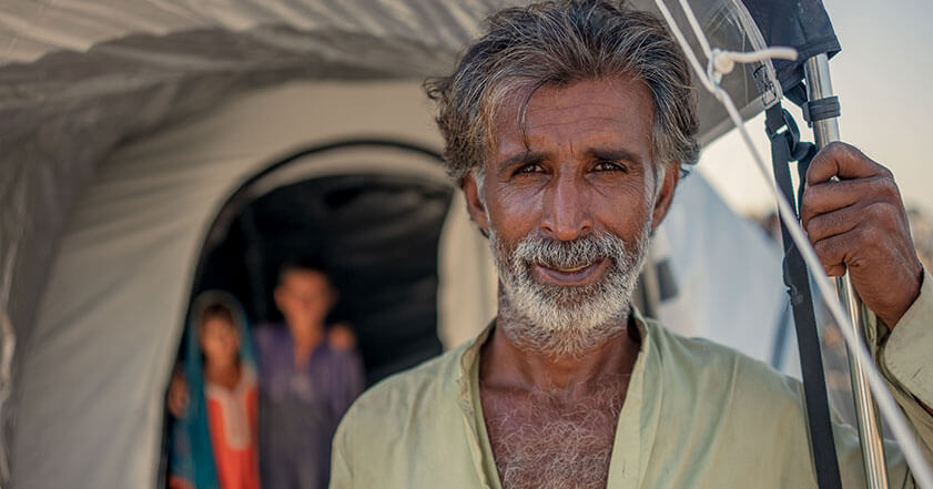 Man stands in front of emergency tent in Pakistan