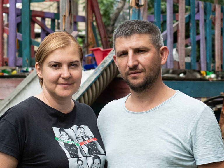 Ukrainian couple stand in front of a children's slide