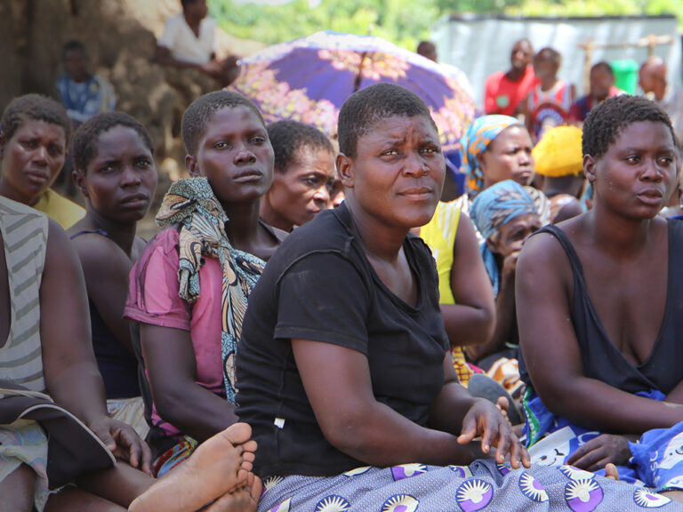 A group of Malawian women sit in the shade