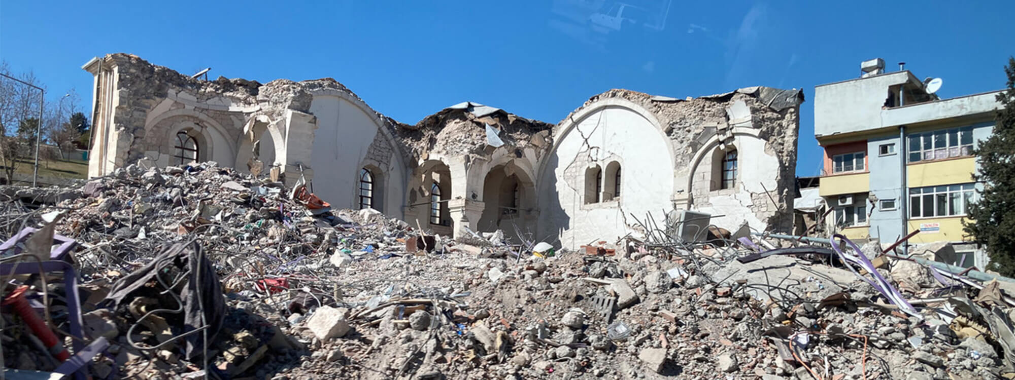 Buildings badly damaged by an earthquake, with rubble around