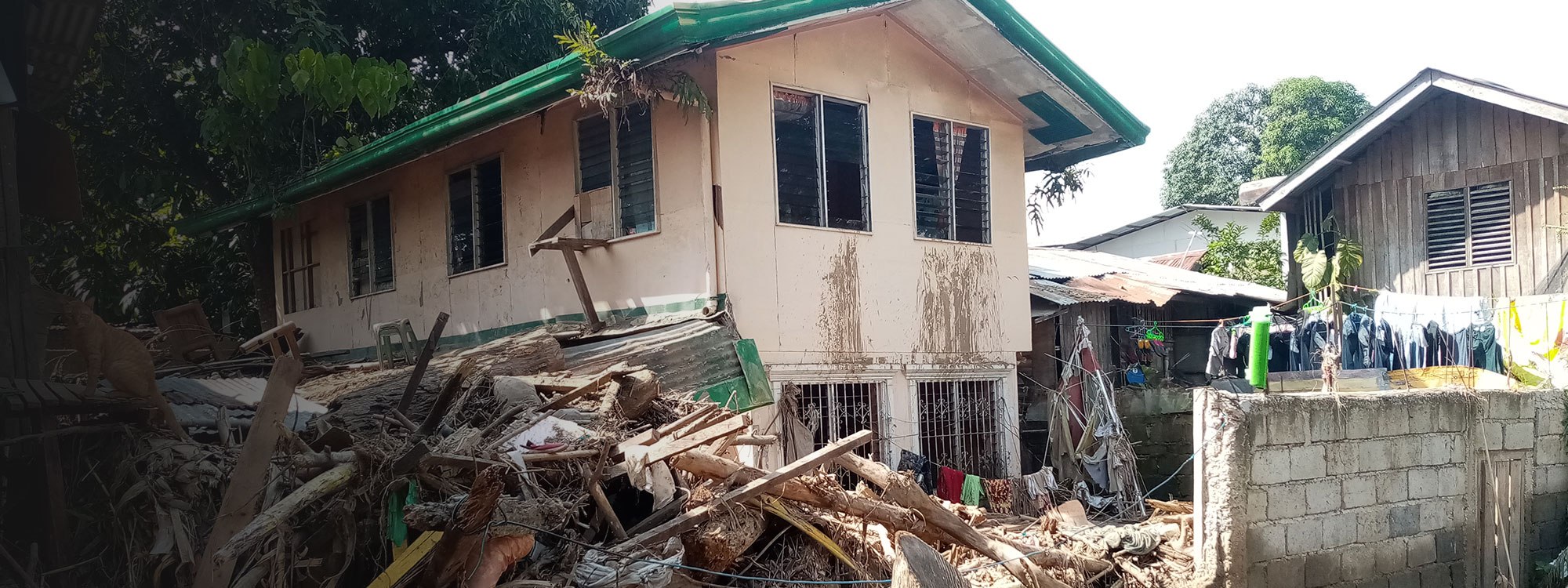 House surrounded by rubble after tropical storm in the philippines