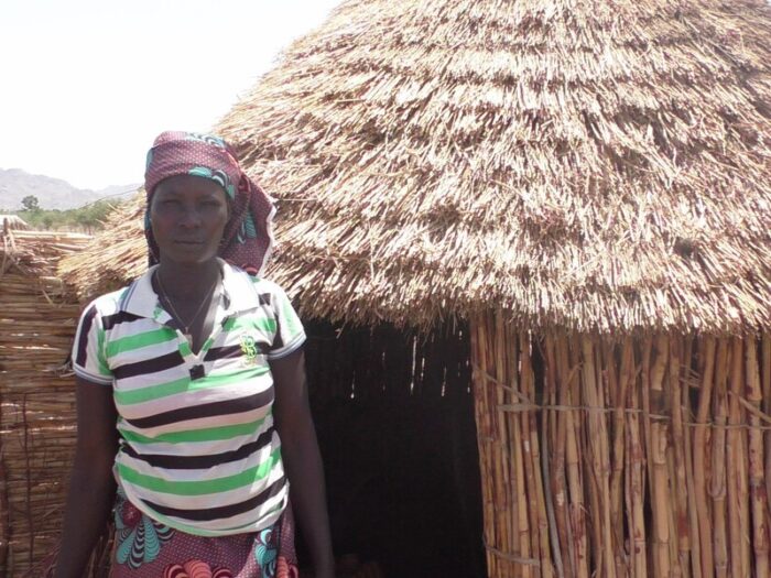 Woman standing next to a house in Cameroon