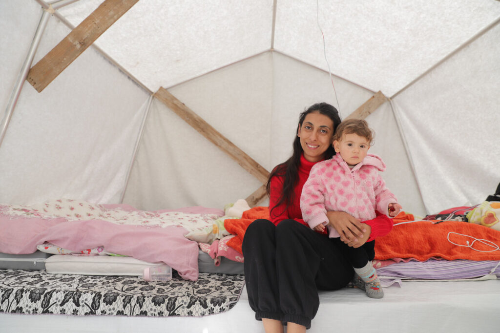 Woman holding a toddler inside a tent in Turkey