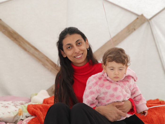 Woman holding a child inside a tent in Turkey