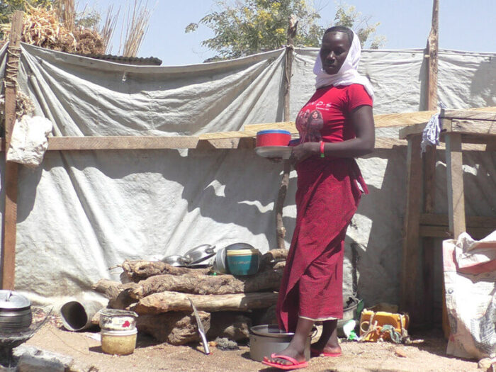 A woman standing in the outside area of her home