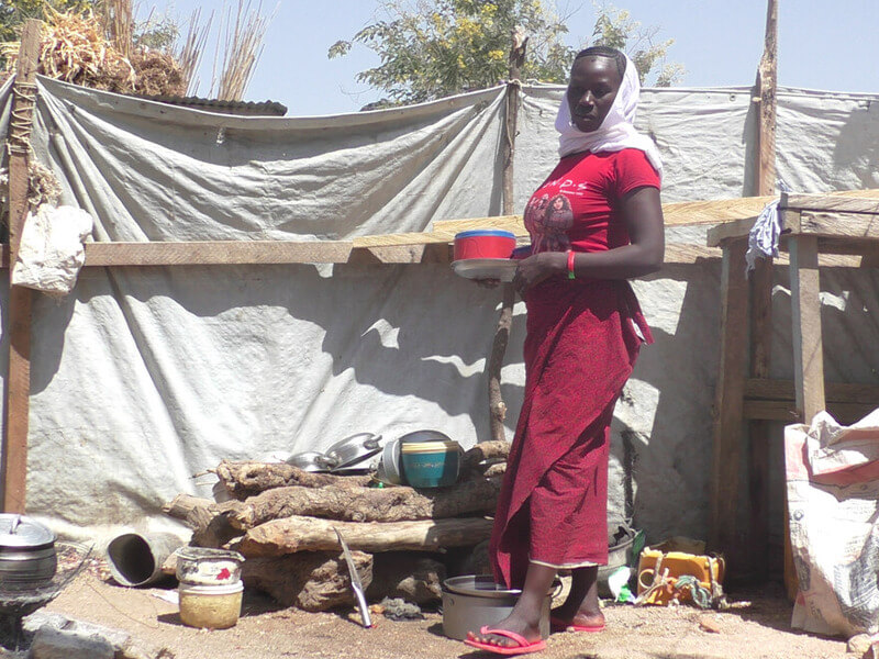 A woman standing in the outside area of her home