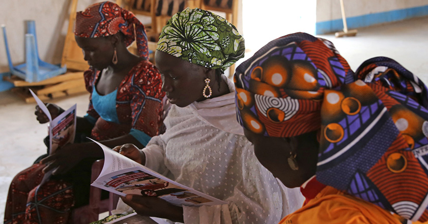 Three women looking at paperwork in Cameroon