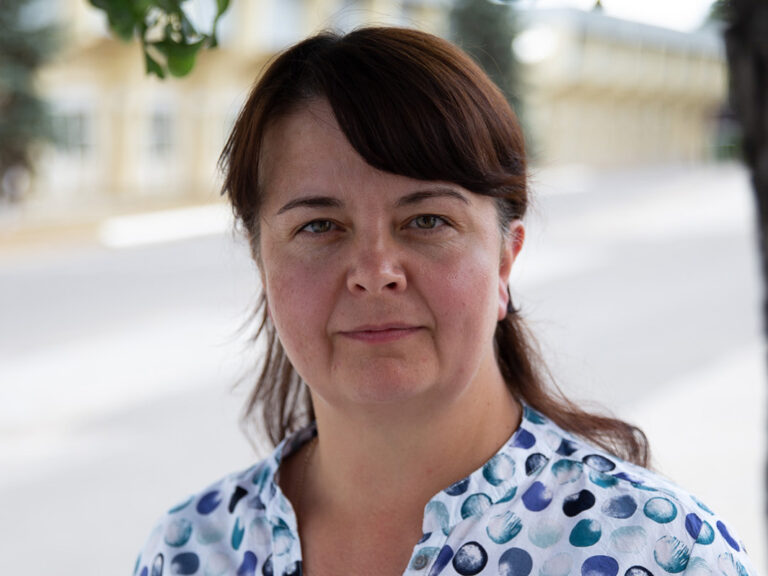 Woman with brown hair next to a tree