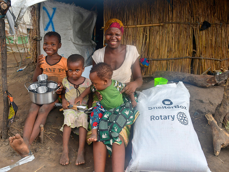 Woman and three children with a bag of ShelterBox aid in Mozambique