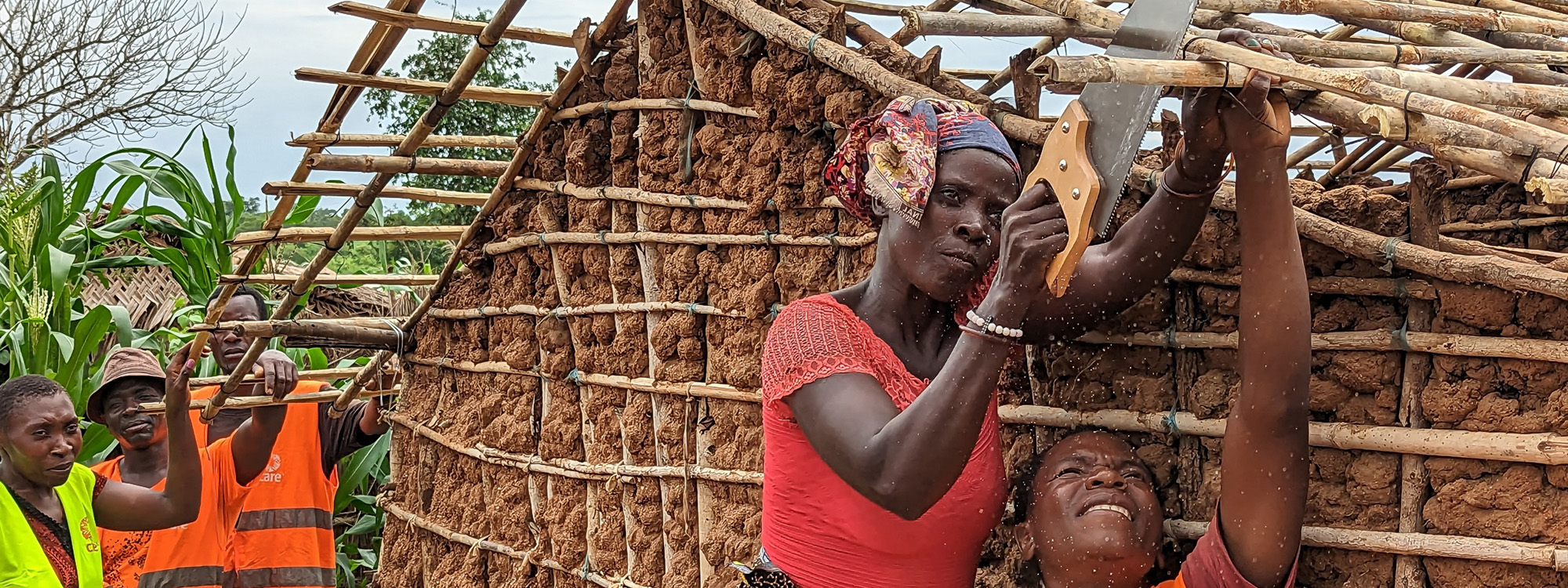 A woman sawing the roof of a new shelter in Mozambique