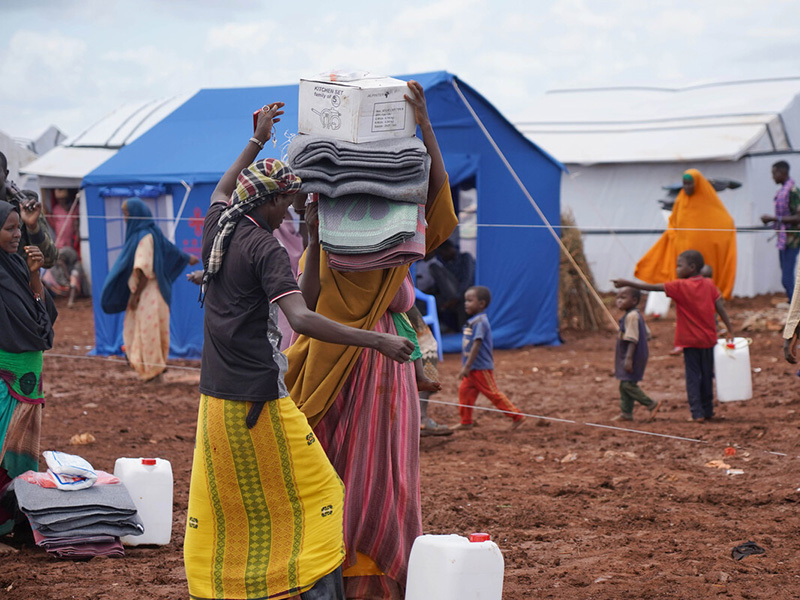 People carrying aid materials such as blankets and water carriers in Somalia