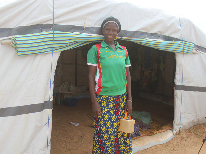 Woman standing in from of a Sahelian tent in Burkina Faso