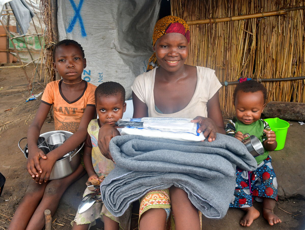Woman and three children holding aid items in Mozambique