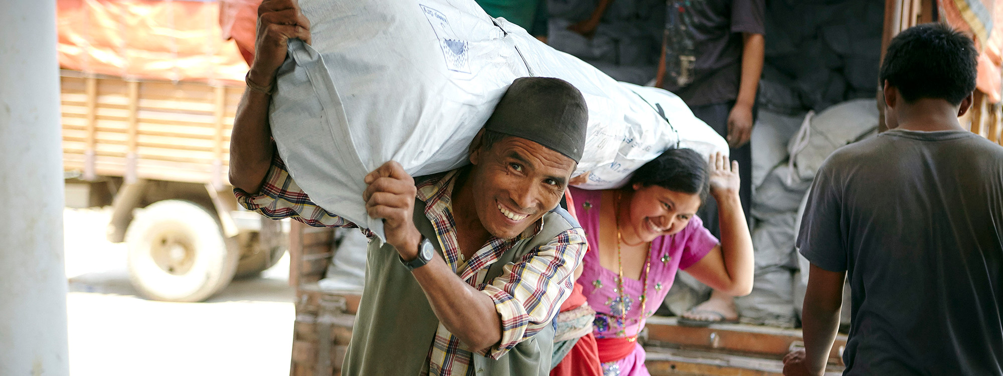 Man and woman carrying a bag of aid in Nepal