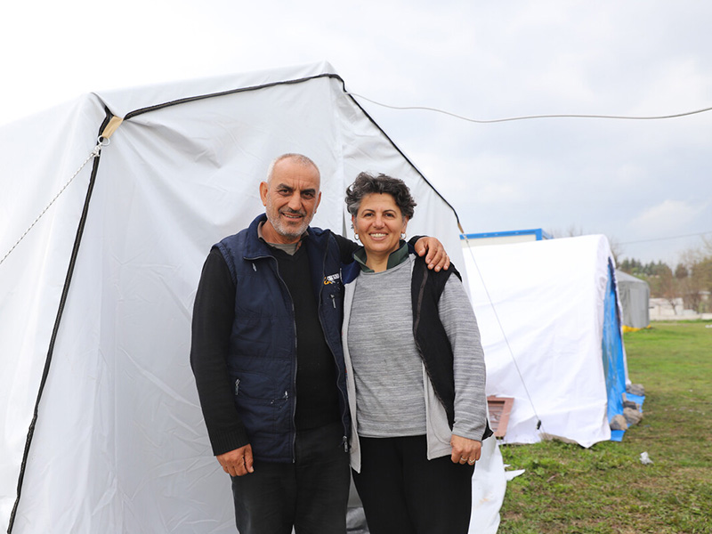 Man and woman standing outside a tent after the Turkey earthquakes