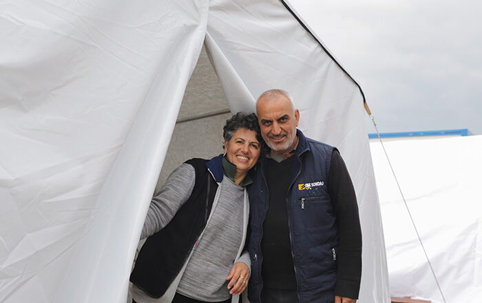 Woman and man standing outside a tent after the Turkey earthquakes