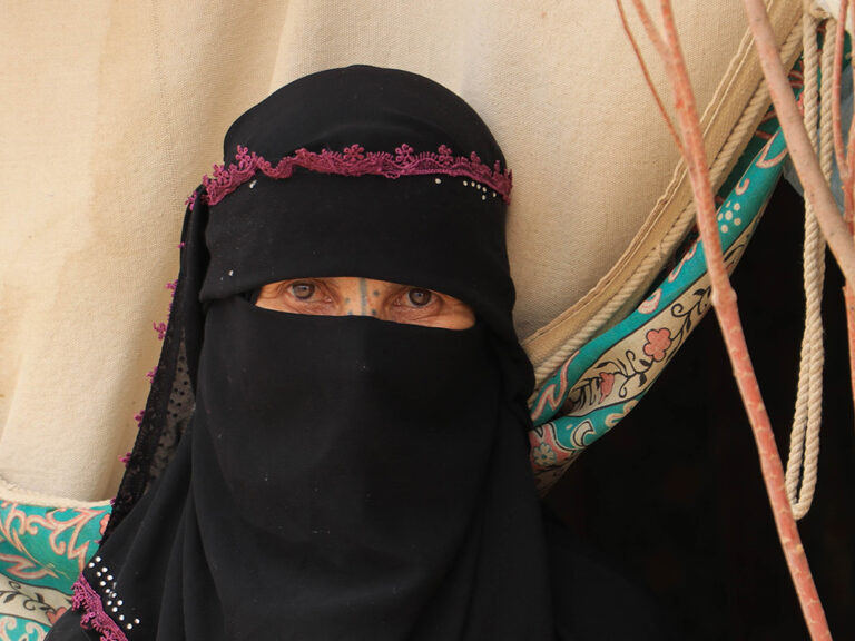 Woman wearing black head scarf and face covering in Yemen