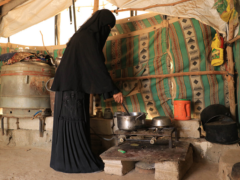 Woman standing stirring the contents of a pot in Yemen