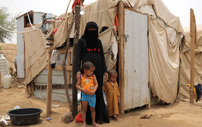 Woman and two children outside a shelter in Yemen
