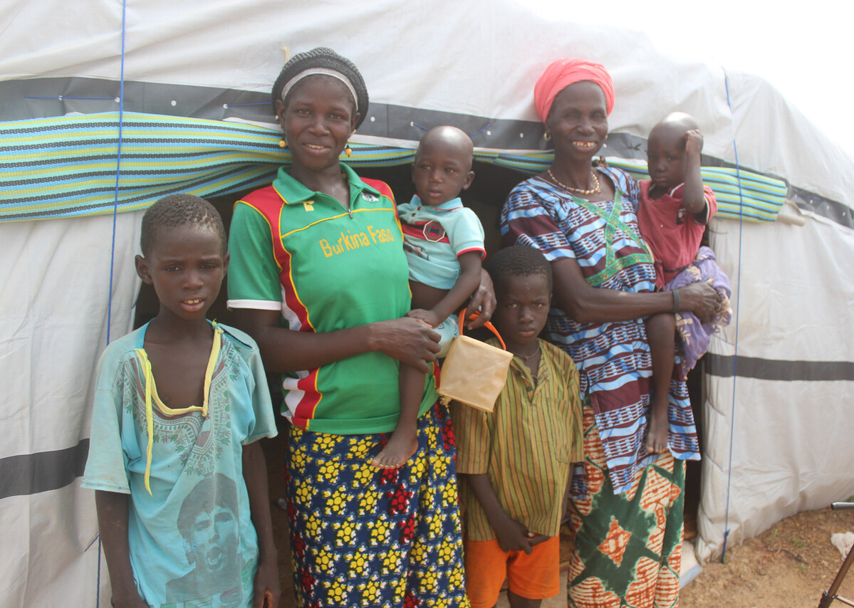 two women and four children standing outside a sahelian tent in Burkina Faso