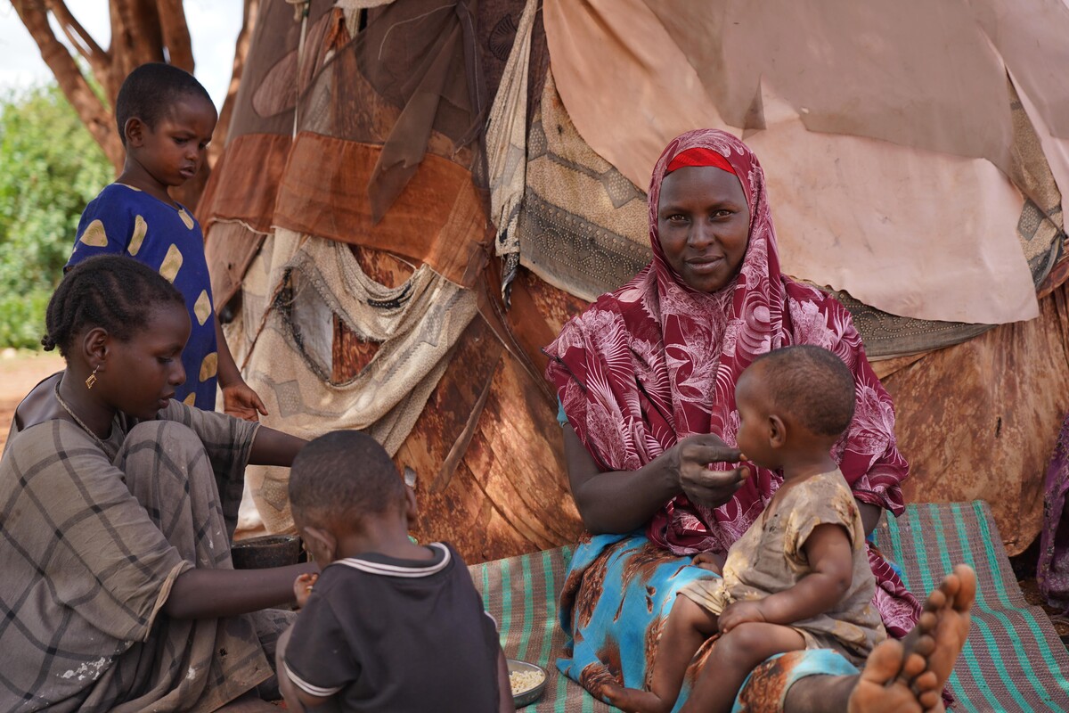 Woman and children sitting outside of a tent in Somalia