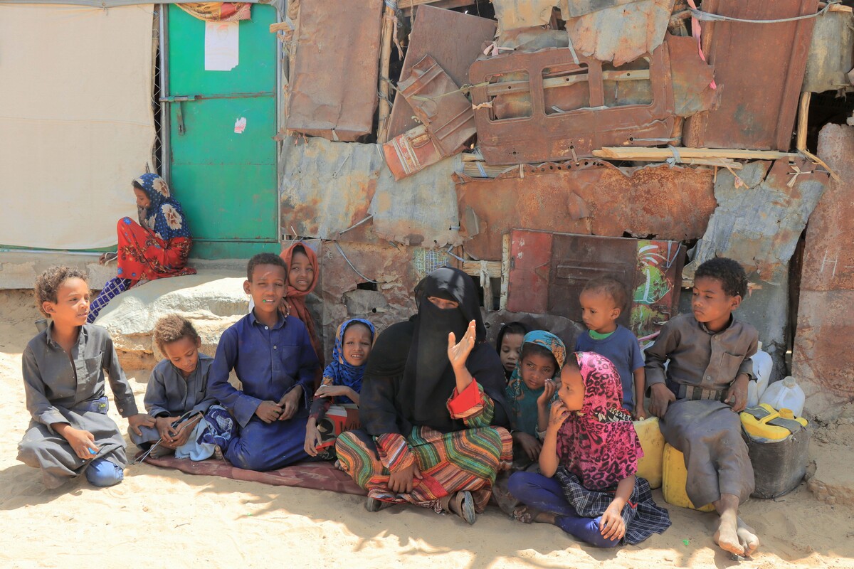 Woman sitting on the floor surrounded by children in Yemen