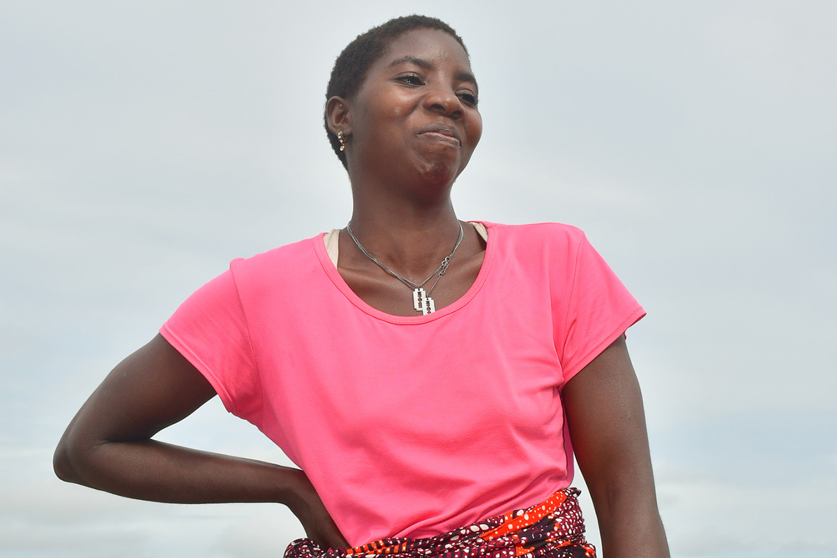 Woman in pink t shirt with hand on hip in Mozambique