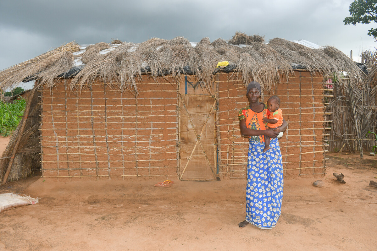 Woman standing outside of her home in Mozambique