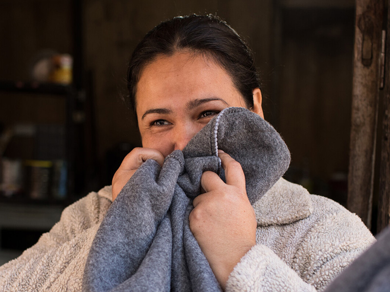 Woman holding a blanket to her face