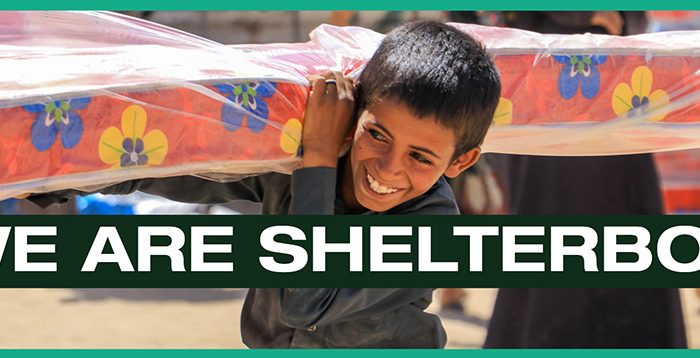 Boy holding mattress with text we are ShelterBox across