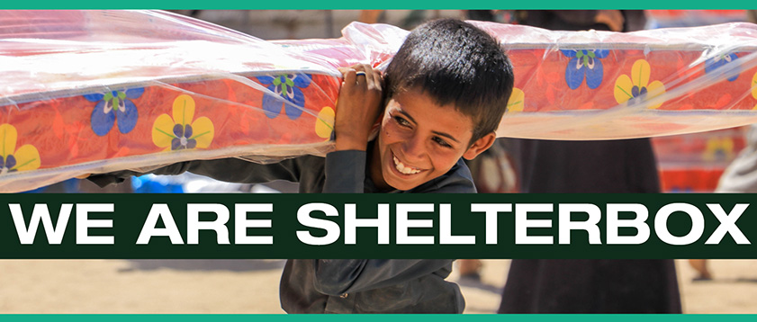 Boy holding mattress with text we are ShelterBox across