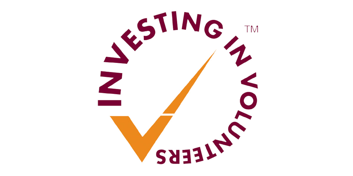 Investing in Volunteers logo (yellow tick with red wording in a circle) on a white background