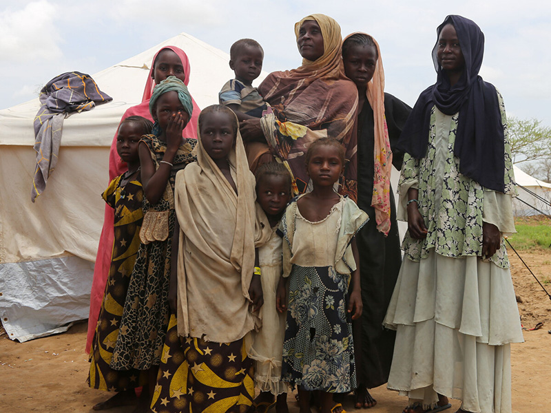Woman and children standing in front of a tent in Chad