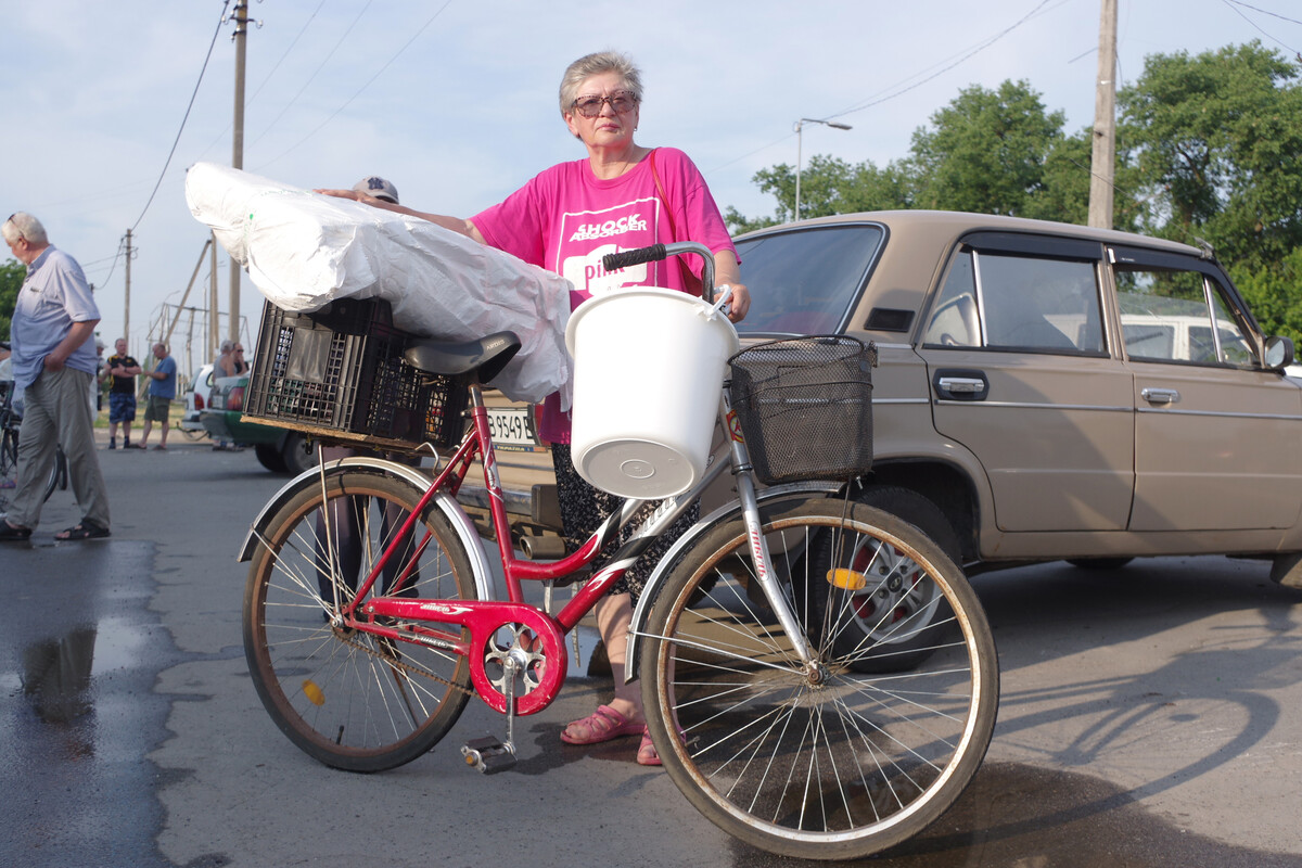 Woman carrying aid on bicycle in Ukraine