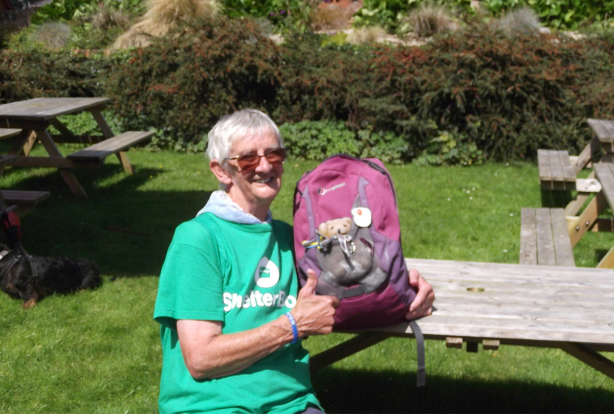 Woman wearing a ShelterBox shirt with a rucksack