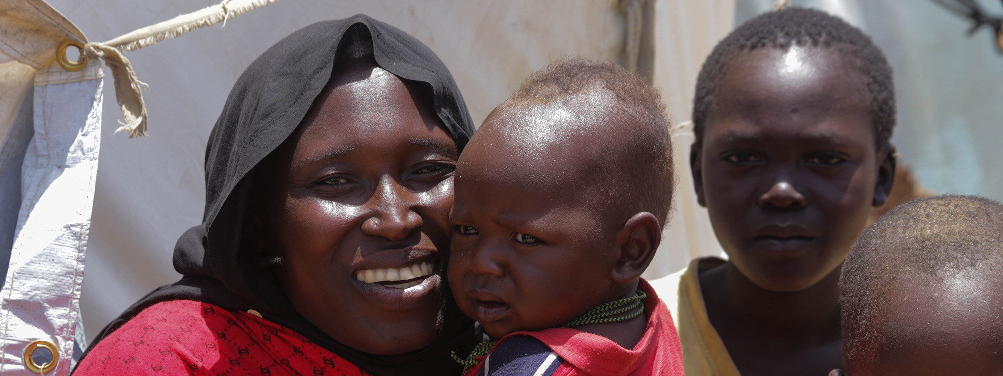 Woman smiling and holding a child in Chad