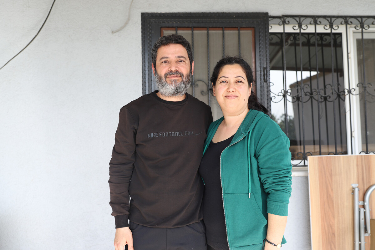 Man and woman outside a home in Turkey damaged by the earthquakes
