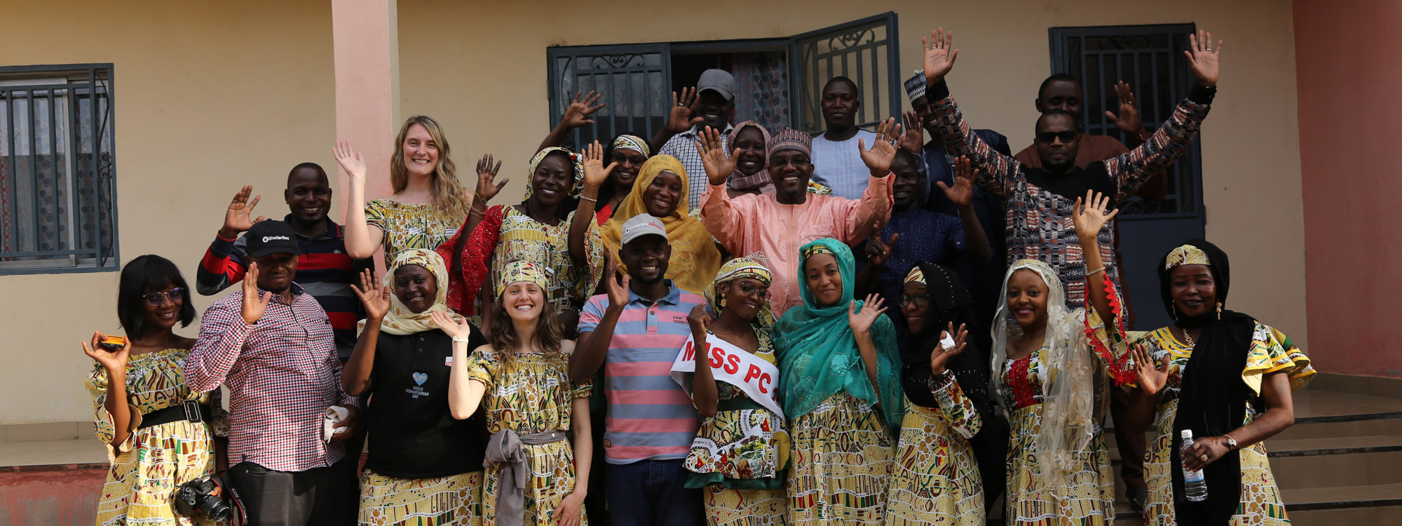 Group of people smiling and waving at camera in Cameroon